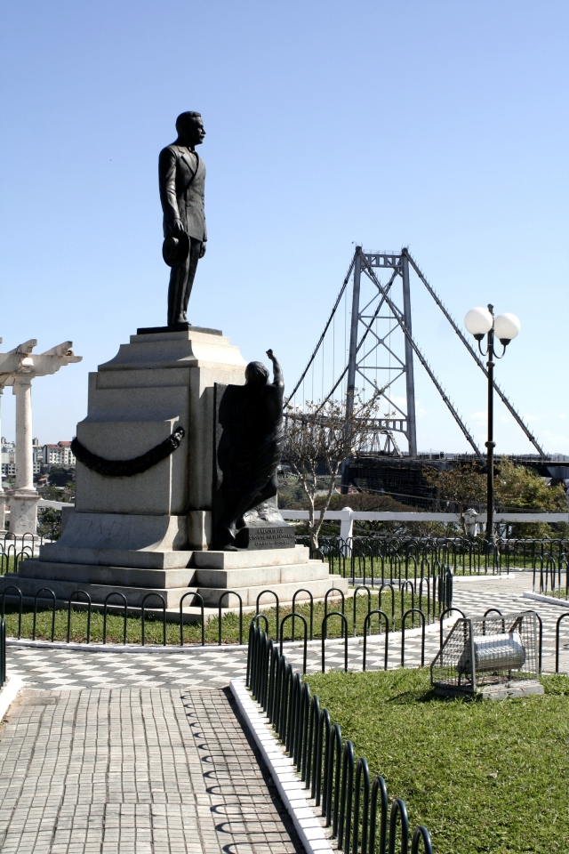 Monumento em Homenagem ao Governador Hercílio Luz tendo ao fundo a Ponte